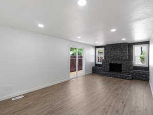 Unfurnished living room with a fireplace and hardwood / wood-style flooring