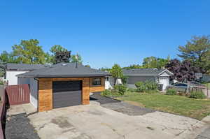 Ranch-style house with a garage and a front lawn