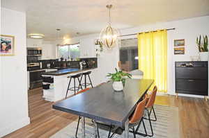 Dining area with a notable chandelier and hardwood / wood-style floors