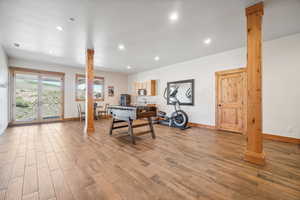 Office featuring light hardwood / wood-style flooring and ornate columns