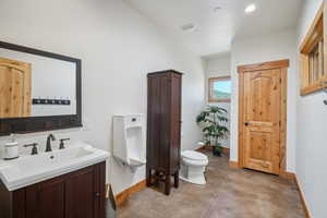 Bathroom with vanity, toilet, and concrete floors