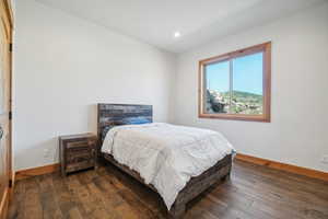 Bedroom with dark hardwood / wood-style flooring