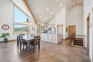 Dining space featuring concrete floors, a wealth of natural light, and high vaulted ceiling