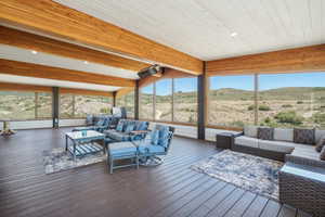 Sunroom with plenty of natural light, wood ceiling, and beam ceiling