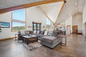 Living room with beam ceiling, french doors, and high vaulted ceiling