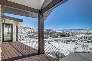 Snow covered deck featuring a mountain view