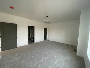 Interior space featuring carpet flooring and a chandelier