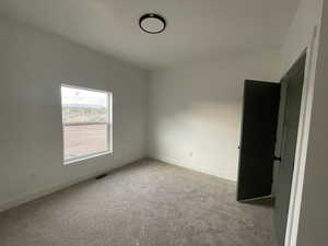 Carpeted spare room with lofted ceiling