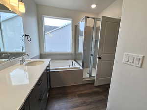 Bathroom featuring vanity, shower with separate bathtub, and hardwood / wood-style flooring