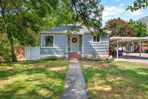 View of front facade featuring a carport and a front yard