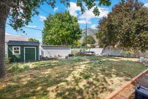 View of yard with a mountain view and a storage shed