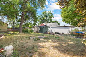 View of yard with a storage shed and a trampoline