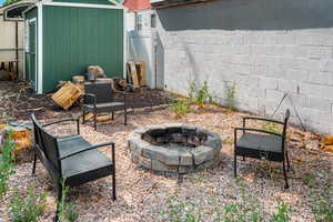 View of patio with a fire pit and a shed