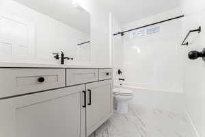 Bathroom with visible vents, tub / shower combination, toilet, marble finish floor, and vanity