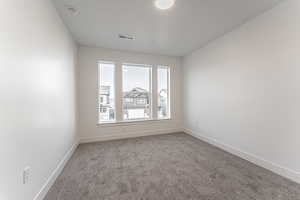 Carpeted empty room featuring baseboards and a textured ceiling