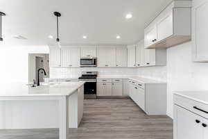 Kitchen with a sink, stainless steel appliances, light countertops, and light wood finished floors
