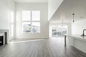 Unfurnished living room with wood finished floors, a fireplace, visible vents, and a textured ceiling