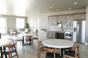 Kitchen with sink, appliances with stainless steel finishes, and light wood-type flooring