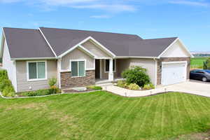 View of front facade featuring a garage and a front lawn