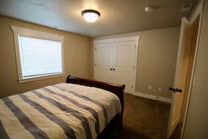 Bedroom featuring dark colored carpet and a closet