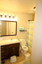 Bathroom featuring vanity, tile patterned flooring, and toilet