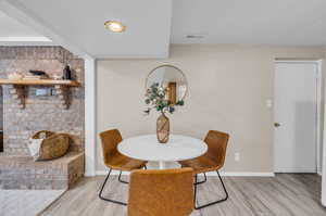 Dining space featuring brick wall and light hardwood / wood-style floors