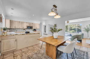 Dining room featuring light tile patterned floors and ornamental molding