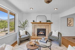 Living room featuring light hardwood / wood-style floors, ornamental molding, and a fireplace