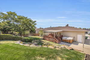 Rear view of house with a patio, a yard, and a wooden deck