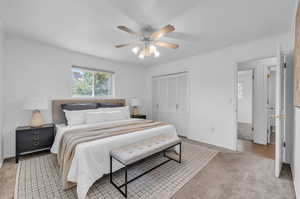 Bedroom with crown molding, a closet, carpet floors, and ceiling fan