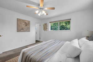 Carpeted bedroom with ceiling fan and ornamental molding