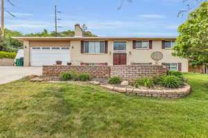 View of front of home with a garage and a front lawn