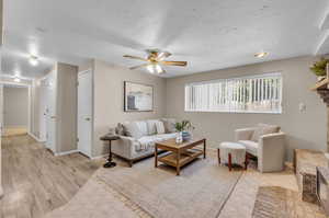 Living room featuring light wood-type flooring and ceiling fan