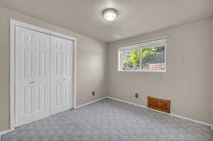 Unfurnished bedroom with a closet and carpet flooring