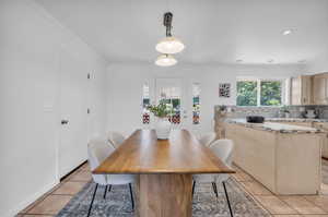 Dining area with crown molding and light tile patterned floors