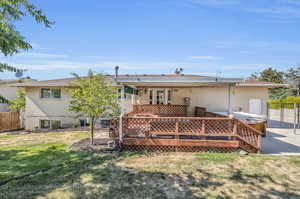 Rear view of house featuring cooling unit, a deck, and a yard