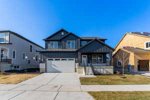 View of front facade with a porch, a garage, and a front lawn