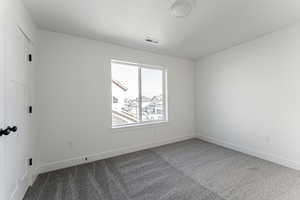 Carpeted spare room featuring a textured ceiling