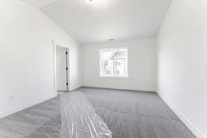 Unfurnished room with lofted ceiling and carpet floors