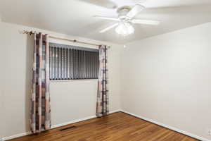 Spare room featuring wood-type flooring and ceiling fan