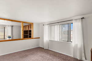 Carpeted empty room featuring a wealth of natural light