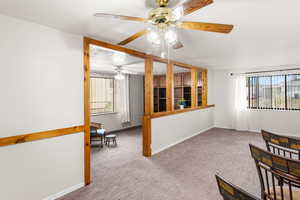 Interior space with carpet floors, ceiling fan, and a healthy amount of sunlight