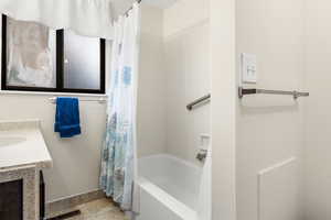 Bathroom featuring vanity, tile patterned flooring, and shower / tub combo