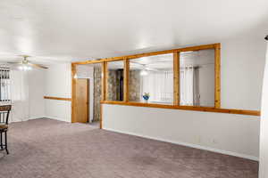 Carpeted spare room featuring ceiling fan