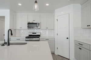 Kitchen with appliances with stainless steel finishes and white cabinetry