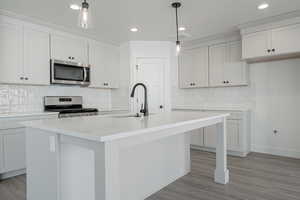 Kitchen featuring tasteful backsplash, a center island with sink, stainless steel appliances, and sink