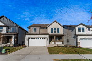 Craftsman-style home featuring a garage and a front lawn