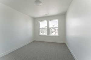 Carpeted spare room with a textured ceiling