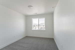 Carpeted spare room featuring a textured ceiling