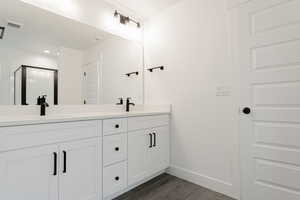 Bathroom with wood-type flooring, vanity, and walk in shower